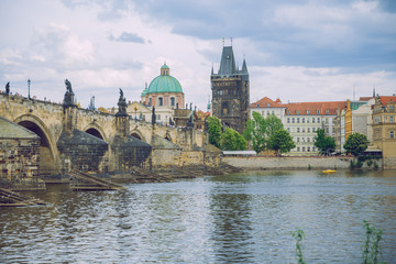Fototapeta premium City Prague, Czech Republic. Tourists on the Charles bridge. Statues along the sides and river Vltava. Travel photo 2019. 25. April