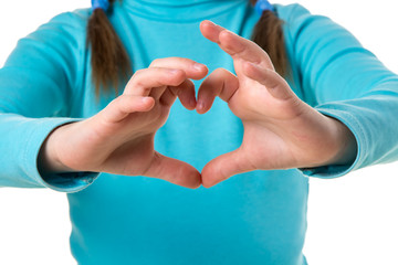 Girl in blue sweater with hands in heart shape close up