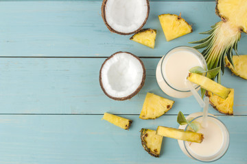 Cocktail Pina Colada. Pina Colada refreshing summer alcoholic cocktail with coconut milk and pineapple juice nearby. summer drink. cocktail preparation. on blue wooden background. top view