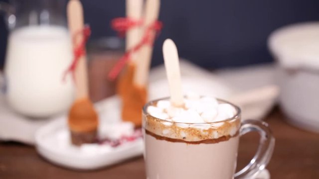 Salted caramel hot cocoa spoon in glass cup.