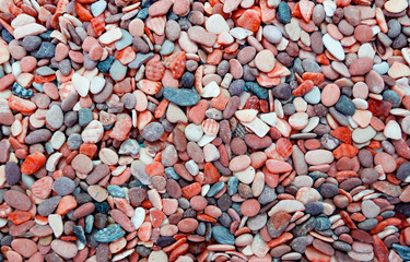 Multicolored round pebbles on the beach. Beautiful background