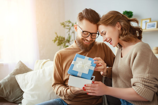 Happy Married Couple Man And Woman Give A Gift For Holiday