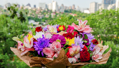beautiful bouquet with different bright colors on a wooden background.