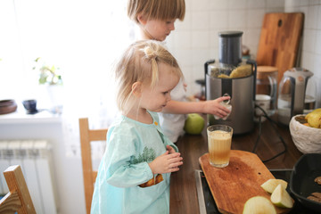Toddler girl brother cut apples and squeeze juice