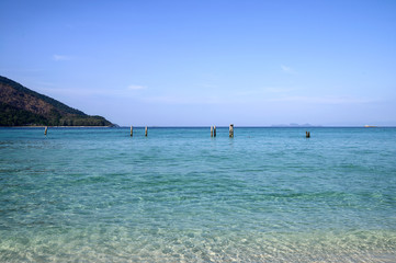 Crystal tropical sea with poles and blue sky