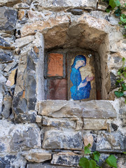 Blue Madonna plaque outside old abandoned building, religious icon, Italy.