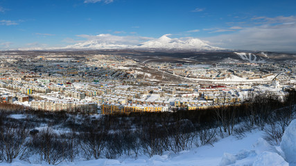 Winter panorama landscape residential buildings of Petropavlovsk-Kamchatsky City, scenery volcanoes of Kamchatka Peninsula: Koryak Volcano, Avacha Volcano, Kozelsky Volcano. Russian Far East, Eurasia.