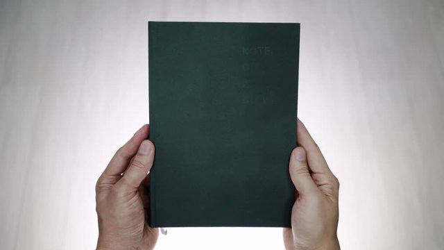 Two hands opening a book with blank pages. Two hands opening a blank book. Blank template for rotoscoping words inside an open book. Holding a book with two hands, it is opened and then closed.