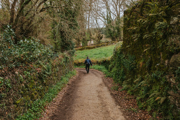 Trekking route in a green landscape and man crossing by walk