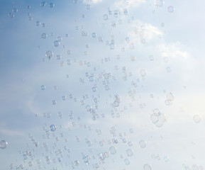 Soap bubbles fly in the blue sky