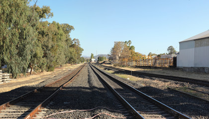 Fototapeta na wymiar double level Railway crossing over a tar road in an industrial area in a small town, rural New South Wales, Australia