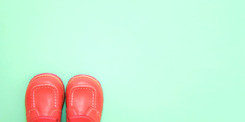 Small shoes fashionable living coral color on a bright background