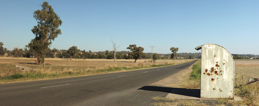 Lone Rural Rustic Rusty Farm Covered School Bus Station Stop On A Long Empty Sealed Road In A Cattle Farming District, Rural New South Wales, Australia