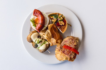 Set of so called pinchos or pintxos - traditional snacks in San Sebastian city also known as Donostia in northern Spain