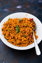 Coconut sambal, a Srilankan/ Indian spicy dish, in a bowl on a textured background.