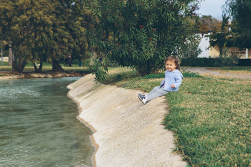 Fototapeta premium Baby girl alone outside in a green park Valencia