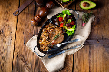 Pork steak with mushrooms and buckwheat groats and mango salad