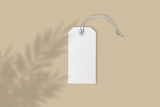 Blank White Price Label Tag On Brown Background With Creative Flower Shadow, Front View Mockup With Copy Space, Close-up Real Picture 