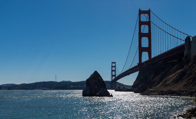 A low angle view of the stunning famous Golden Gate Bridge seen from scenic Baker Beach against a bright blue sky on a sunny day, San Francisco, California, USA