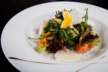 Salad with egg, red pepper, cheese and tomato served on a plate.