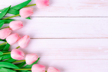 Women's day, Mother's day, Valentine's day concept Pink tulips bouquet on white wooden background, top view and copy space for card and advertiser.