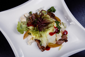 Appetizing salad sliced with pear slices of prosciutto pear arugula and parmesan