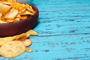Beer snacks like crackers, chips, cookies on a wooden surface