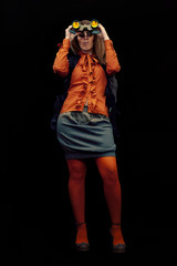 A dynamic and self-confident woman watching around with a pair of binoculars, in semi-darkness....