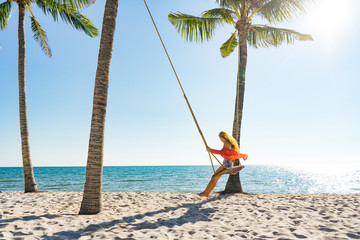 Vacation concept. Young woman swing on a beach swing. Happy traveller women on the Phu Quoc beach
