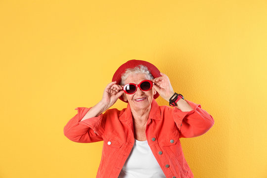 Portrait of cool grandmother on color background