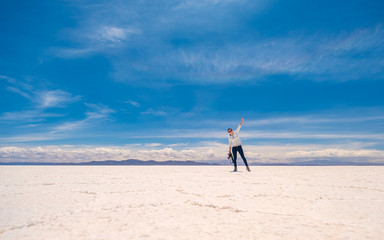 Girl in a jump in sunshine Salar de Uyuni