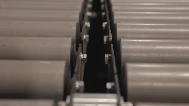Close up of rolling tubes, with camera tilt movement. Elements from the production chain within a massive printing facility, newspaper, magazine, billboards, and any commercial print is made here. 