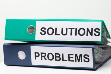 Problems and Solutions - two binders with text on desk in the office