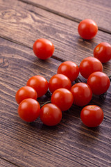 Fresh ripe garden tomatoes lying on wooden table. Side view with copy space.