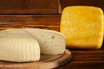 Natural farm cheese on a wooden background.