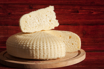Homemade farm cheese on red background. Natural products