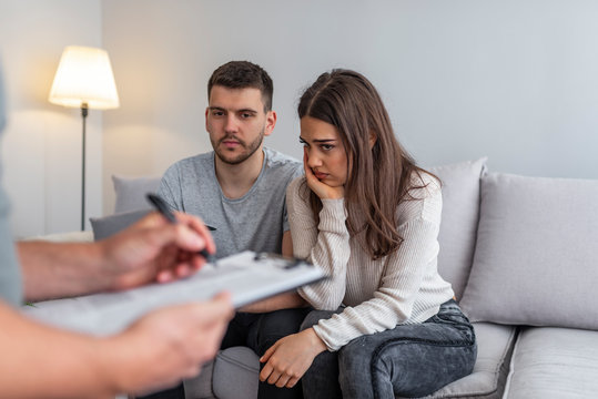 Picture of counselor and couple with problem during therapy. Photo of husband arguing with wife during therapy with psychologist. Young couple having marriage counselling