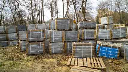 paving stones packed in stacks stored on ground outdoors