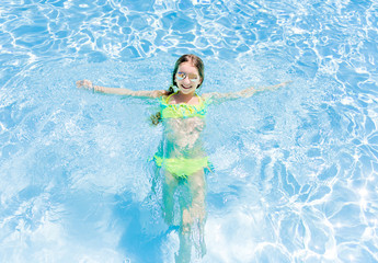 Girl swimming in swimsuit in transparent sea