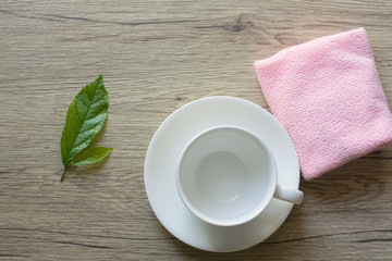 Close up woman hand cleaning coffee cup on the morning with microfiber cloth,Close up woman hand cleaning coffee cup on the rustic wood table.