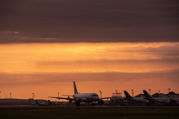 Naklejka na ściany i meble DENPASAR/BALI-APRIL 23 2019: Flight activity at the Ngurah Rai International Airport in Bali where the aircraft is preparing to take off when the sky is in the evening of orange
