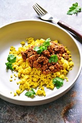 Cauliflower rice with turmeric and beef beef bolognese sauce. Paleo and keto diet dish