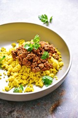Cauliflower rice with turmeric and beef beef bolognese sauce. Paleo and keto diet dish