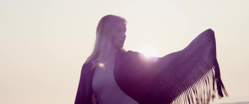 Junge h&uuml;bsche Frau vor dem Sonnenuntergang von Schevening in Holland