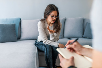 Psychologist listening to woman in trouble during therapy session. Psychotherapist understanding problems of a woman patient. Cropped image of depressed man at the psychotherapist. - obrazy, fototapety, plakaty