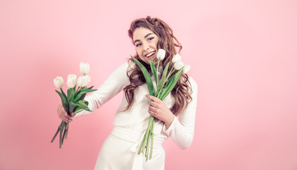 Young girl with tulips on a colored background