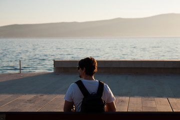 Man sitting on bench and looking at the sea