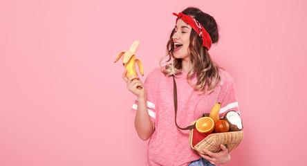 Portrait of a girl with healthy food, fruits, on a pink background