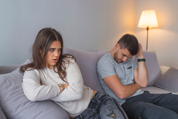 Naklejka na ściany i meble People, relationship difficulties, conflict and family concept - Unhappy couple having argument at home. Couple Having Argument At Home. Troubled woman expressing despair