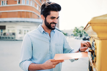 Young businessman sending a folder and documents via mailbox. Business, lifestyle concept